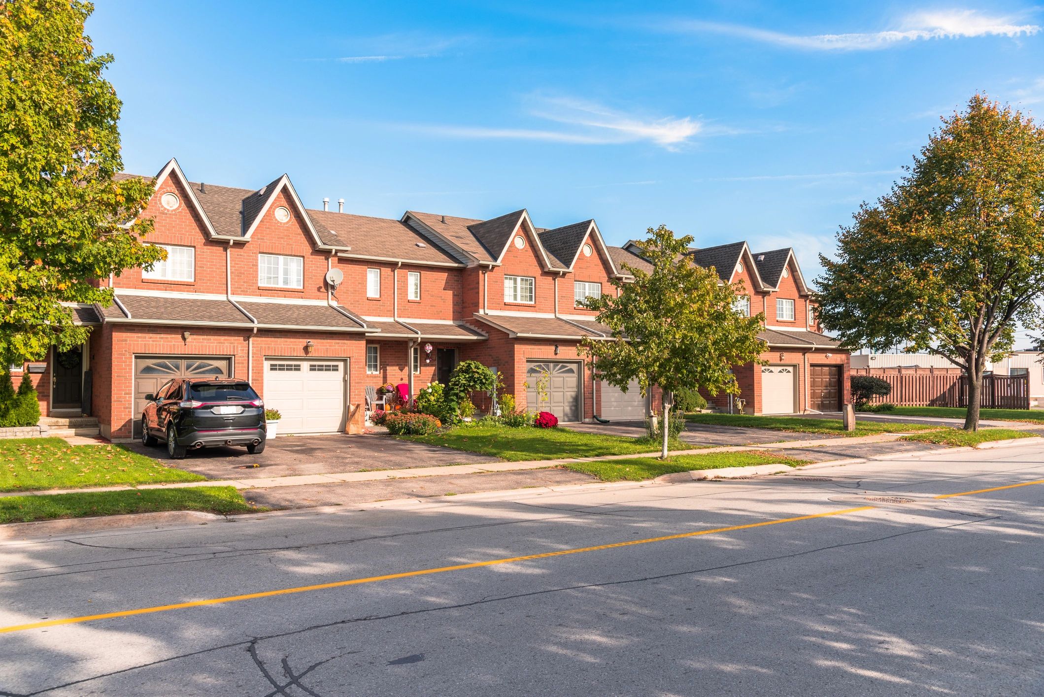 New red brick row houses along a street.